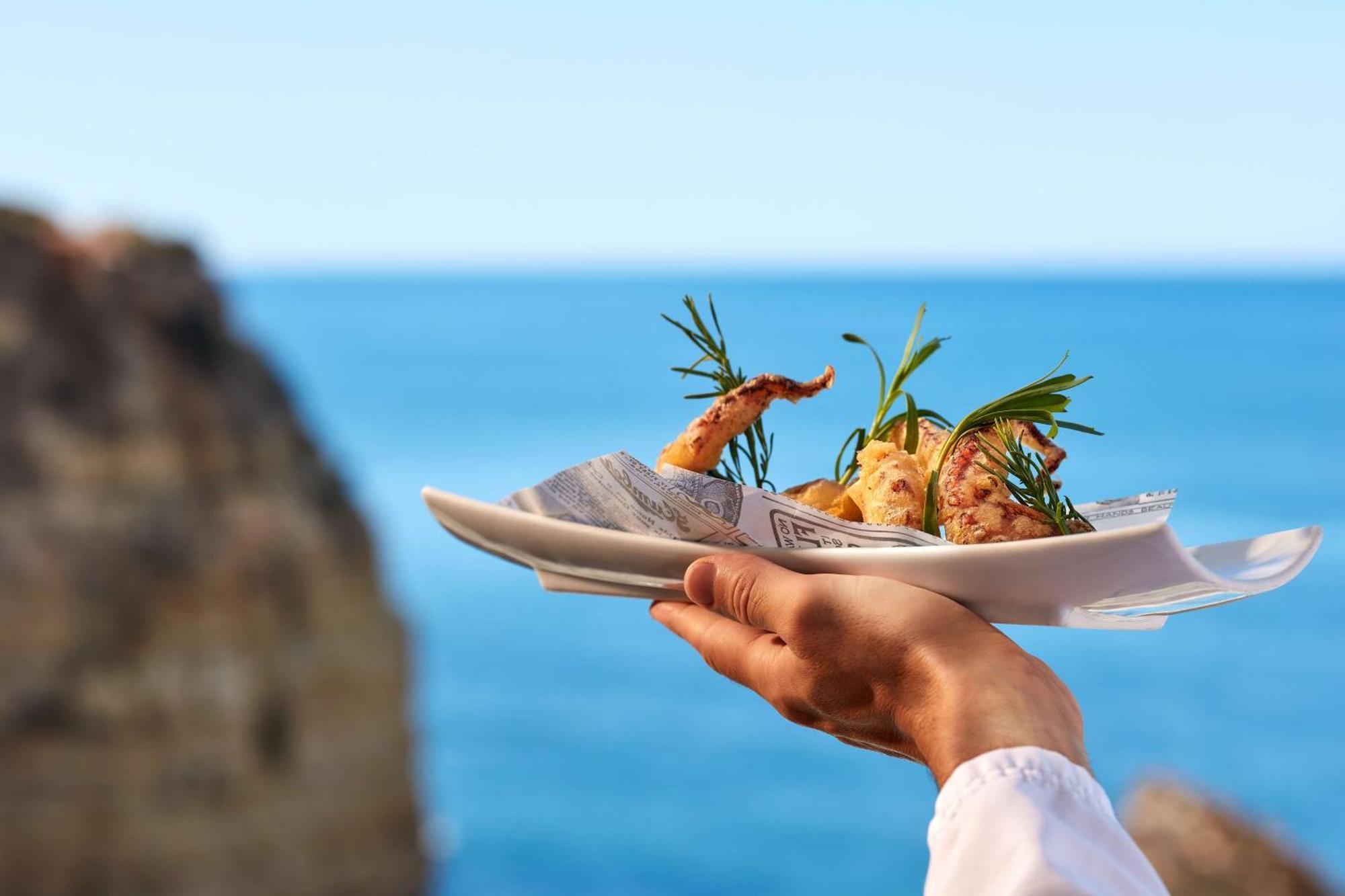 ホテル チボリ カルボエイロ カルヴォエイロ エクステリア 写真 A waiter holding a plate of food